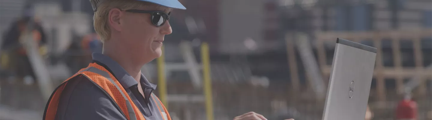 Worker with laptop on jobsite