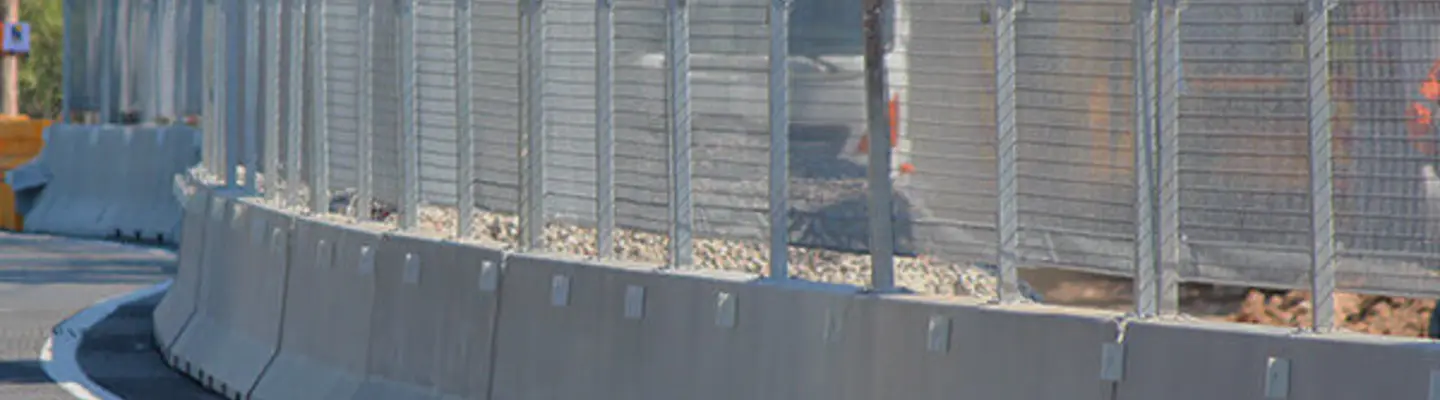Safety barriers barricading a road construction zone to protect workers and guide vehicle traffic safely around the site.
