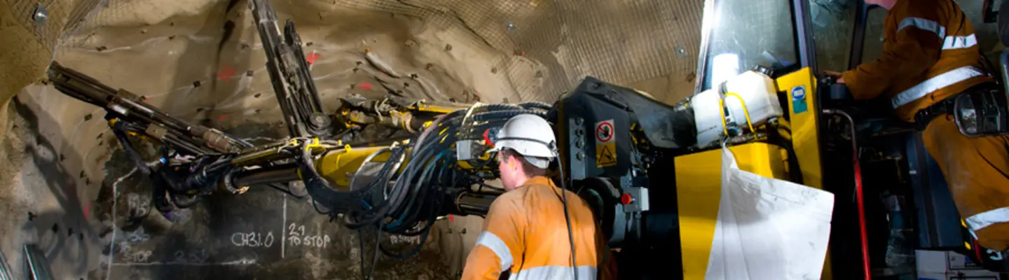 Excavators and heavy equipment digging underground at a construction site for barrier foundation or utility installation.