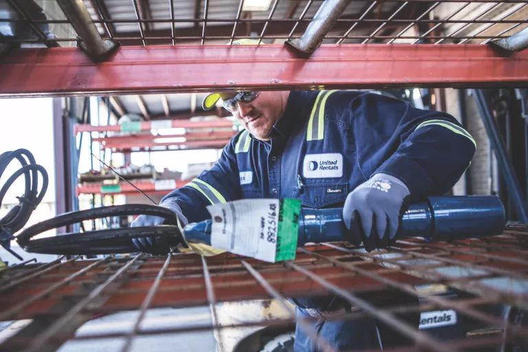 worker grabbing tool off shelf
