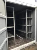 white shipping container with shelves on the inside and both doors open