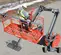 Top view of a worker standing in an elevated orange boom lift with safety railings, operating controls outdoors.