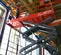 Bottom upward angled view of a red Skyjack scissor lift with gray base, extended indoors in a construction site.