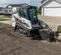 White and black BOBCAT Compact Track Loader digging dirt