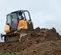 Orange and black Case bulldozer with low ground pressure pushing dirt up an incline