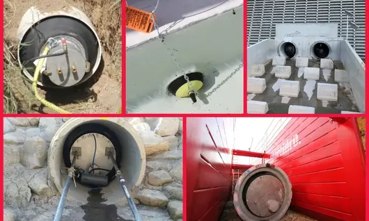 Excavation site showing a hole with visible pipe plugs, surrounded by safety cones and construction barriers.