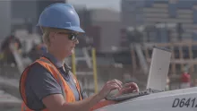 Worker with laptop on jobsite