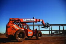 Orange JLG forklift with United Rentals branding against a blue sky