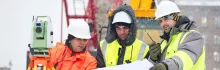 workers in safety vests and hard hats at a construction site in the winter