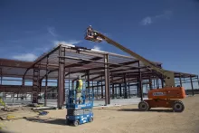 Workers using lifts at a job site