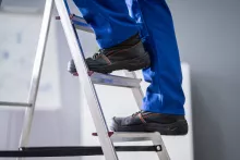 man in boots climbing ladder