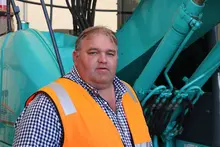 Manager overseeing installation of safety barriers at a construction site to ensure worker protection.