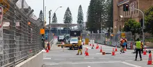Workers installing pole barriers on a city street to enhance road safety and manage traffic flow.