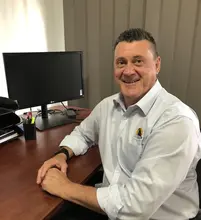 Account Manager sitting at his desk in front of a computer, reviewing project budgets and barrier installation costs.