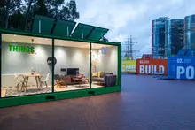  Exhibition space featuring shipping containers arranged creatively to display art or products in a modern, industrial setting.