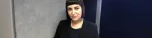 Woman smiling confidently in a professional setting, introduced as the company’s new Human Resources Officer.